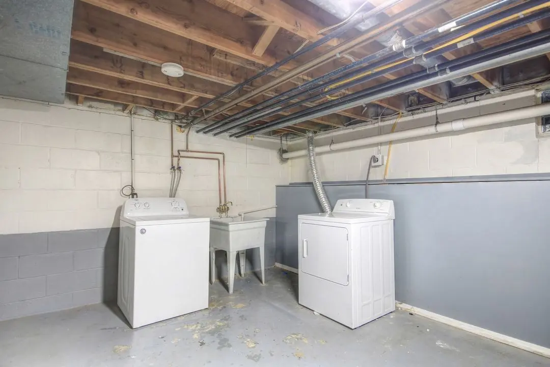 Washer, dryer, and utility sink in the basement laundry area