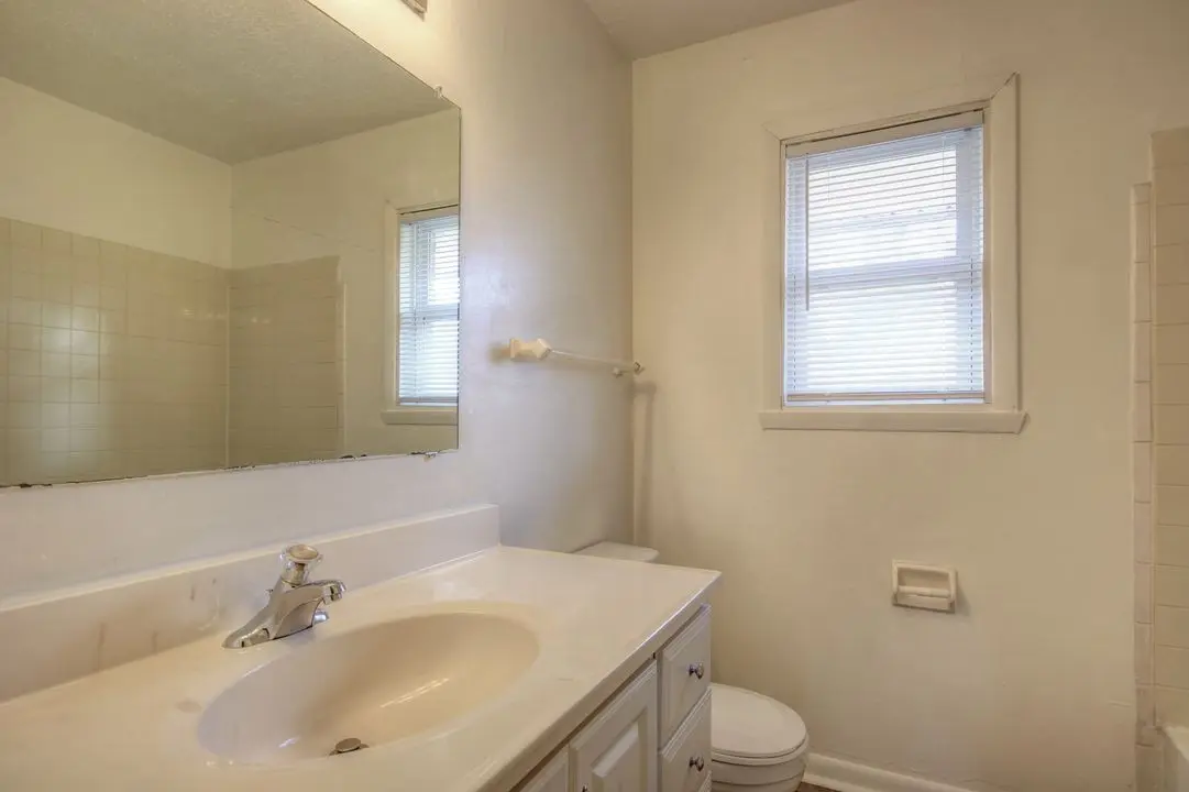 Full bathroom with tub and shower, vanity, and window