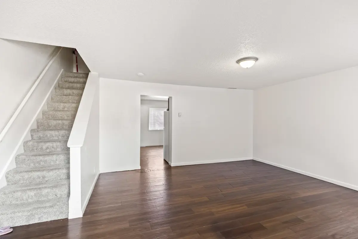 Townhome living room with wood-style flooring and the staircase leading up to the bedrooms